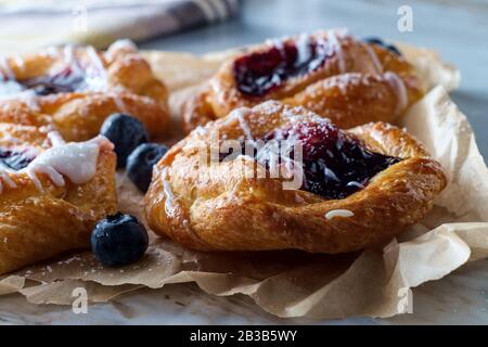 Blaubeere, glasierte dänische Dessertgebäcke mit Puderteis und Puderzucker Stockfoto