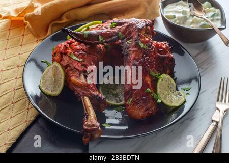 Indische Küche würziges rotes Tandoori-Hähnchen mit Gurken-Raita Stockfoto