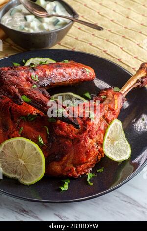 Indische Küche würziges rotes Tandoori-Hähnchen mit Gurken-Raita Stockfoto