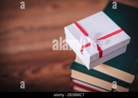 Das Geschenk des Lernkonzepts - kleine Präsentkiste auf einem Stapel Bücher Stockfoto