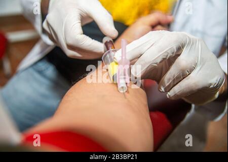 Krankenschwester, die Blutprobe vom Patienten im Arztbüro abnimmt Stockfoto