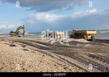 Hayling Island, Hampshire. Erdbewegungsmaschinen werden verwendet, um Strandkies jedes Jahr von West nach Ost zu verschieben, um der Wirkung von Landwölbungen entgegenzuwirken Stockfoto