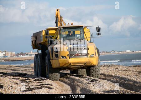 Hayling Island, Hampshire. Erdbewegungsmaschinen werden verwendet, um Strandkies jedes Jahr von West nach Ost zu verschieben, um der Wirkung von Landwölbungen entgegenzuwirken Stockfoto