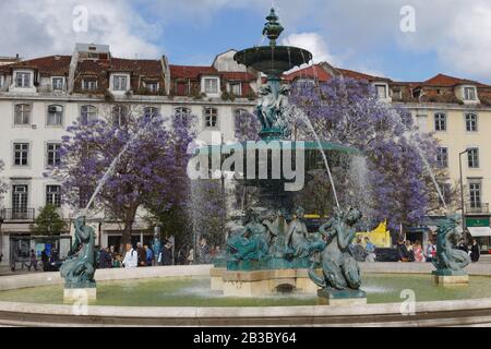 Menschen am Brunnen auf dem König Pedro IV Platz, im Volksmund bekannt als Rossio Platz, in Lissabon, Portugal Stockfoto