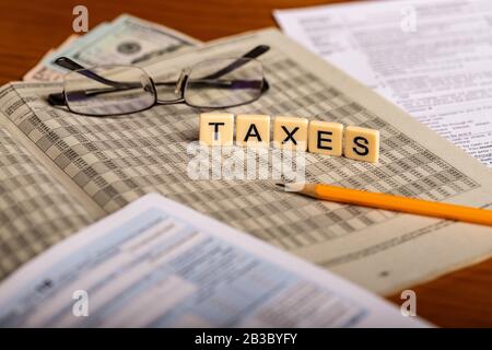 Konzeptbild von Steuerformen mit Brille, Geld und Bleistift Stockfoto