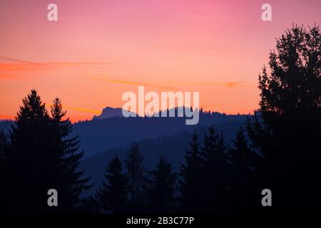 Schöne Landschaft - greller Sonnenaufgang in den Bergen. Schöne Silhouetten der Berge Stockfoto
