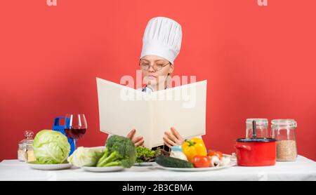 Kochkonzept zu Hause. Küchenchefin nach Rezepten suchen. Kulinarische Anleitung im Internet. Restaurant-Menü-Design. Meisterklasse für kulinarische Kunstkochung. Gourmetküche vom Koch. Stockfoto