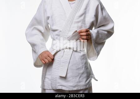 Stufen der korrekten Bindung des Bandes durch einen Teenager auf einem Sportkimono, Schritt sechs Stockfoto