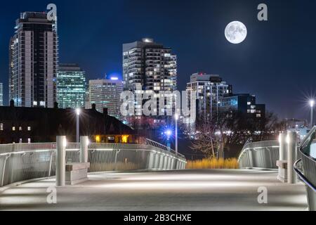 Nacht In Calgary. Ein großer Mond in Calgary. Fußgängerbrücke in der Nachtstadt. 2019 Stockfoto