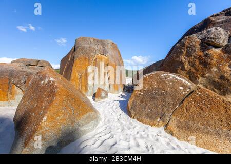 Riesige orangefarbene Felsbrocken auf dem berühmten Quietschenden Strand in Wilsons Prom, Australien Stockfoto