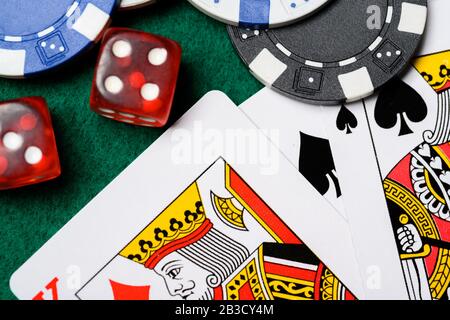 Pokerchips, Spielkarten und Würfel auf einem grünen Backgrorund. Glücksspiel Stockfoto