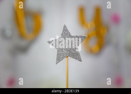 Silberner Sternenschmuck mit Glitzer über grauem Hintergrund. Weihnachten einfache Komposition minimales Konzept mit Platz für Kopien. Stockfoto