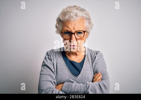 Senior schöne grauhaarige Frau mit legeren Pullover und Brille über weißem Hintergrund skeptisch und nervös, missbilligend Ausdruck im Gesicht mit Stockfoto