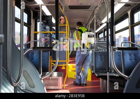 Larry Bowles, Wartungstechnist bei King County Metro, wendet am 4. März 2020 Desinfektionsmittel mit einer Chemiespritze auf einem Reisebus auf der King County Atlantic Base in Seattle an. Anfang der Woche hatte die Agentur die Reinigungshäufigkeit ihrer Flotte von 1.600 Bussen auf ein tägliches Verfahren als Reaktion auf neuartige Coronavirus erhöht. King County Metro hat nun die Methode eingeführt, Virex II 256 Desinfektionsmittel mit einer chemischen Spritze zum Schutz der Passagiere zu verwenden. Stockfoto