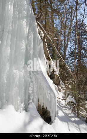 Wunderschöne, sonnenbeleuchtete Eiswände auf den Felswänden entlang eines Pfades im Algonquin Park Canada im März. Stockfoto