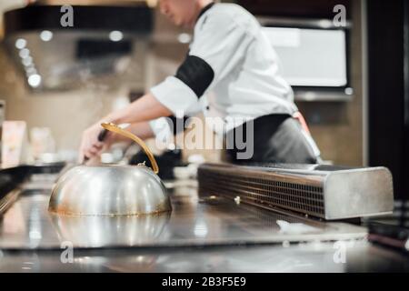 Vom Mann wird Fleisch mit Gemüsegrill zubereitet, vom Küchenchef wird wagyu-rind im japanischen Teppanyaki-Restaurant gekocht Stockfoto