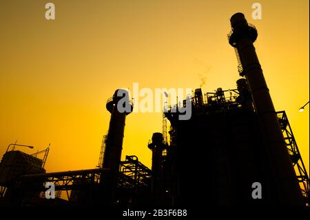 Petrochemische Anlage in Silhouettenbild bei Sonnenuntergang Stockfoto