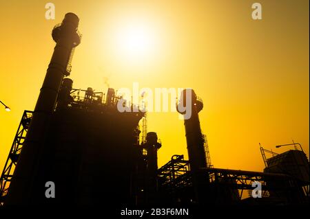 Petrochemische Anlage in Silhouettenbild bei Sonnenuntergang Stockfoto