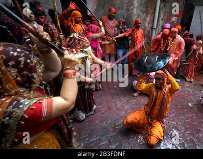 Ein Hindu-Mann, der von Frauen mit Stock bei Barsana geschlagen wurde, nannte sich Lathmar holi. Das Festival begann 1 Woche vor dem eigentlichen Holi-Datum. Der Mythos hinter diesem Lathmar Holi steht im Zusammenhang mit dem Hindu-Gott Lord Krishna, der gemäß dem lokalen Glauben aus seiner Heimatstadt Nandgaon an seinen Lovers Place bei Barsana kam und Radha und ihre Freunde neckte. Mit diesem gemeinsamen Glauben seit mehr als 100 Jahren pflegen Frauen von Barsana immer noch das Ritual und schlagen die Außenseiter von Nandgaon mit Stöcken (Lathi), um die Tradition an diesem bestimmten Tag aufrechtzuerhalten. Stockfoto