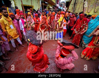 Hindu-Männer, die von Frauen mit Stock bei Barsana geschlagen wurden, als Lathmar holi genannt. Das Festival begann 1 Woche vor dem eigentlichen Holi-Datum. Der Mythos hinter diesem Lathmar Holi steht im Zusammenhang mit dem Hindu-Gott Lord Krishna, der gemäß dem lokalen Glauben aus seiner Heimatstadt Nandgaon an seinen Lovers Place bei Barsana kam und Radha und ihre Freunde neckte. Mit diesem gemeinsamen Glauben seit mehr als 100 Jahren pflegen Frauen von Barsana immer noch das Ritual und schlagen die Außenseiter von Nandgaon mit Stöcken (Lathi), um die Tradition an diesem bestimmten Tag aufrechtzuerhalten. Stockfoto