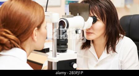 Augenarzt im Untersuchungsoptikerlabor mit weiblicher Patientin. Augenpflege Stockfoto