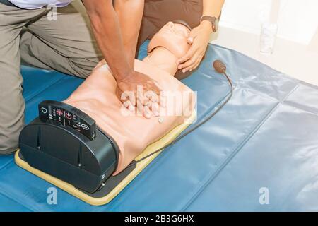 Hlw-Beihilfen dummy medizinische Ausbildung mit der Hand drücken Sie Herz auf Puppe Notfall Refresher Training Konzept geschlossen. Stockfoto