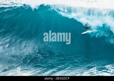 Ein einsamer Surfer, der eine große Welle auf Hawaii genießt. Stockfoto