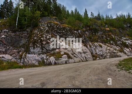 Typische karelische Landschaft in der Umgebung von Sortavala: Ein Wald aus Nadelbäumen, Spuren vulkanischer Lava, Felsen und vulkanischen Gesteinen. Russland, Karelien Stockfoto