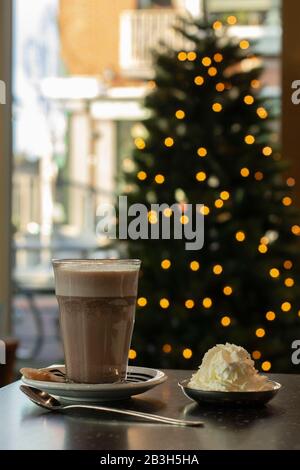 Heiße Schokolade vor dem Weihnachtsbaum Stockfoto