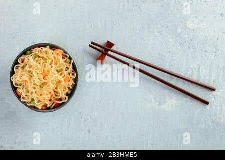 Soba-Schüssel mit Karotten und Hengsten, Gemüsesoba-Schüssel, Kopfschuss mit Essstäbchen und Kopierraum Stockfoto