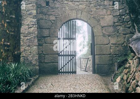 Sintra, Portugal - 18. Januar 2020: Eingang mit Gating an der maurischen Burg an einem sehr nebligen Tag Stockfoto