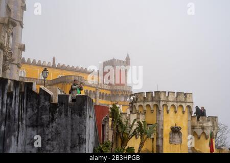 Sintra, Portugal - 18. Januar 2020: Der Touristenmann scheint von nebligen Ansichten enttäuscht zu sein, als er mit seinem Telefon im Pena Palace fotografiert Stockfoto