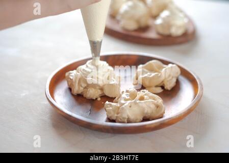 Der Prozess, Pavlova Dessert zu kreieren und das Meringue mit Sahne zu schmücken Stockfoto