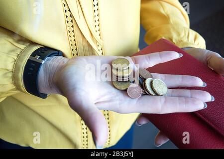 Frau, die kleine Veränderungen in ihrer Handfläche festhält. Euro-Cent-Münzen aus dem Geldbeutel genommen. Geldkonzept. Mangel an Ressourcen. Stockfoto
