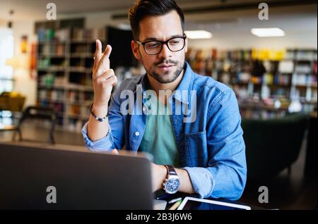 Der Schüler bereitet die Prüfung und den Lernunterricht in der Schulbibliothek vor Stockfoto