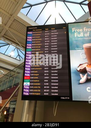 Die Flugabflugstafeln, die stornierte Flüge am Flughafen Belfast als Flybe, Europas größte regionale Fluggesellschaft, zeigen, sind in die Verwaltung eingebrochen. Stockfoto