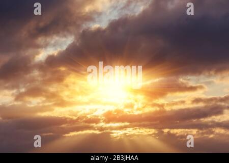 Göttliches Leuchten durch die Wolken der abendlichen warmen Sonne. Konzept des Friedens und des Glücks Stockfoto