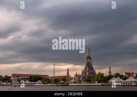 Der berühmte buddhistische Tempel Wat Arun bei Sonnenuntergang gegen einen dramatischen Himmel, Bangkok, Thailand Stockfoto