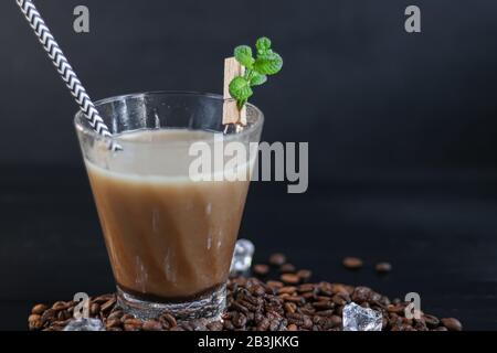 Eiskaffee in einem hohen Glas mit Milch und Eisstücken. Auf dunklem Hintergrund. Kopierbereich Stockfoto
