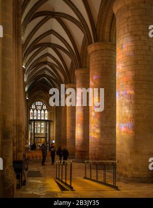 Sonnenlicht überströmt Glasfenster auf die Hauptpiere in der Kathedrale von Gloucester. Stockfoto