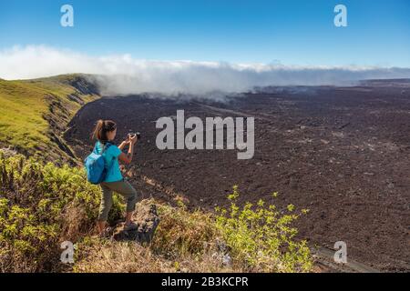 Galapagos Touristenwanderung auf dem Vulkan Sierra Negra auf Isabela Island Fotos mit der Kamera machen. Frau auf Wanderung auf berühmtem Wahrzeichen, der zweitgrößten aktiven Vulkancaldera der Welt, Galapagos-Inseln Ecuador. Stockfoto