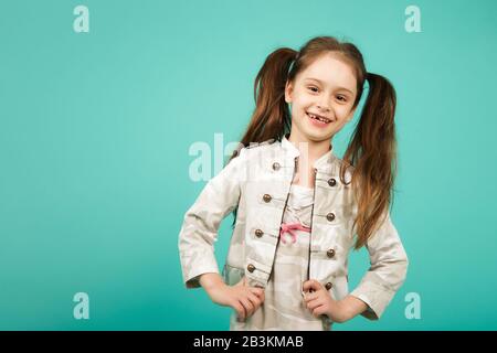 Süßes junges Mädchen hat einen Zahn verloren. Kind, dem ein Vorderzahn fehlt. Lustige zahnlose Mädchen lachen. Stockfoto