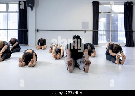 Mixed Race moderne Tänzerinnen, die sich in einem Studio ausdehnen Stockfoto