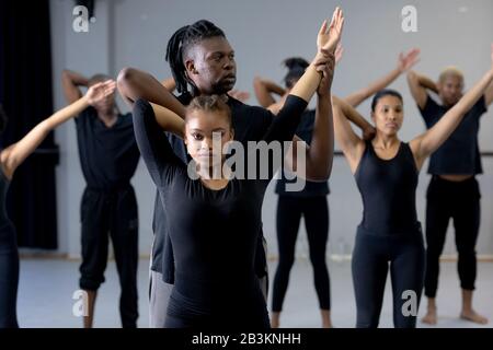 Tänzerin hilft modernen Tänzern, eine Tanzroutine in einem Studio zu üben Stockfoto