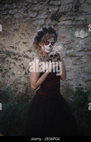 Nahaufnahmen von Calavera Catrina. Junge Frau mit Zuckerschädel-Make-up. Dia de los muertos. Tag der Toten. Halloween. Im Wald mit Schädel Stockfoto