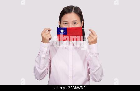 Asian Woman mit hygienischem Gesichtsmaskenbild Taiwan-Flagge zum Schutz vor dem Coronavirus 2019 (COVID-19) Infektionsausbruch, dem Virus oder Stockfoto