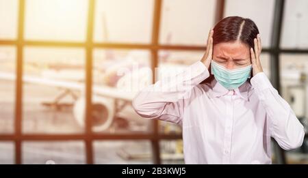 Asiatische Touristen fühlen sich krank, haben ein Fieber, tragen eine hygienische Gesichtsmaske, um während der Reisezeit am Flughafenterminal zu verhindern, um vor dem neuen Co zu schützen Stockfoto