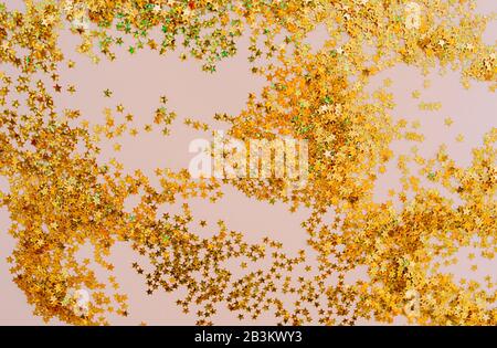 Abstrakter Hintergrund Gold glänzende kleine Sterne auf einem rosa zarten Hintergrund. Stockfoto