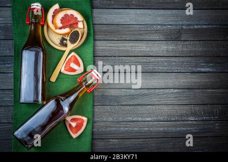 Kombucha Superfood pro biologischer Teepilz Getränk im Glasbecher mit Grapefruit auf dunklem Hintergrund. Mit grünem Textil. Kopierraum Stockfoto