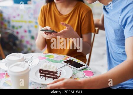 Nahaufnahme des Paares mit Handy in einem Café Stockfoto